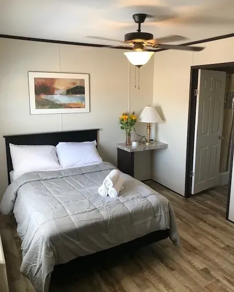 Furnished single lodge room with bed and window at Mesquite Oasis