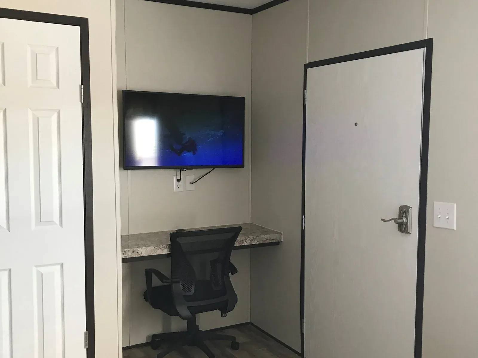 Interior of a furnished lodge unit at Mesquite Oasis, showing the work space and window