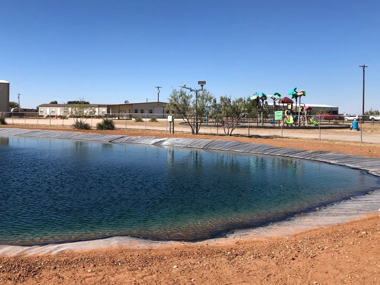 Pond and play area at Mesquite Oasis Lodge & RV Park in Odessa, Texas