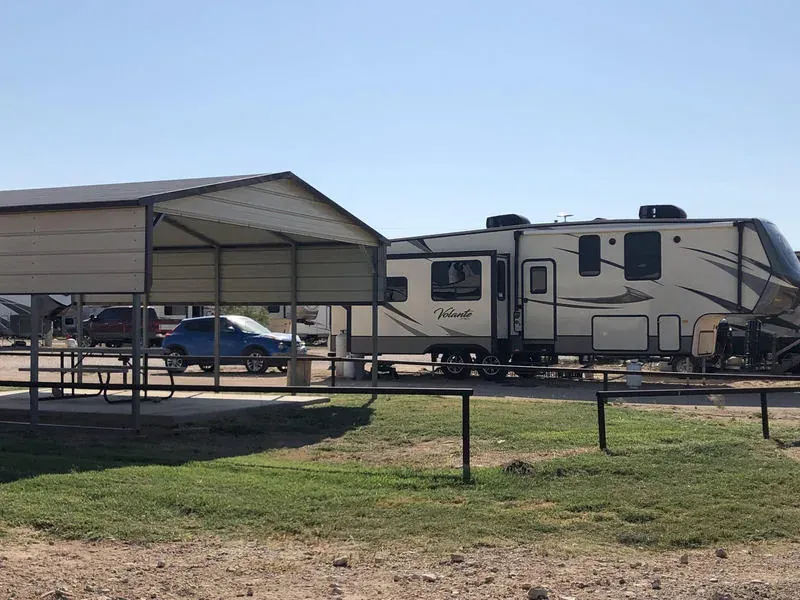 Covered RV site with paved pad and picnic area at Mesquite Oasis